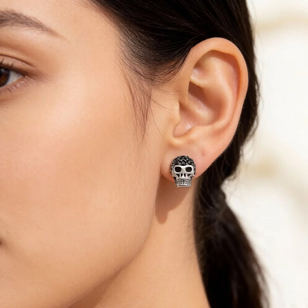 Boucle d'oreille tête de mort à zircons noirs portée par une femme