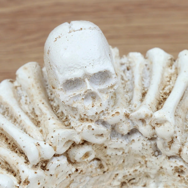 Détail du cendrier tête de mort Halloween en résine ivoire, avec crâne sculpté et ossements en relief