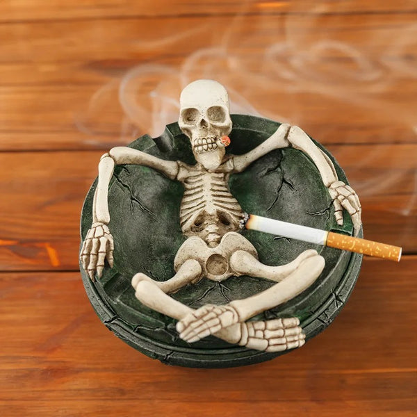 Cendrier tête de mort rond en résine avec squelette ivoire assis, crâne et cigarette sculptée